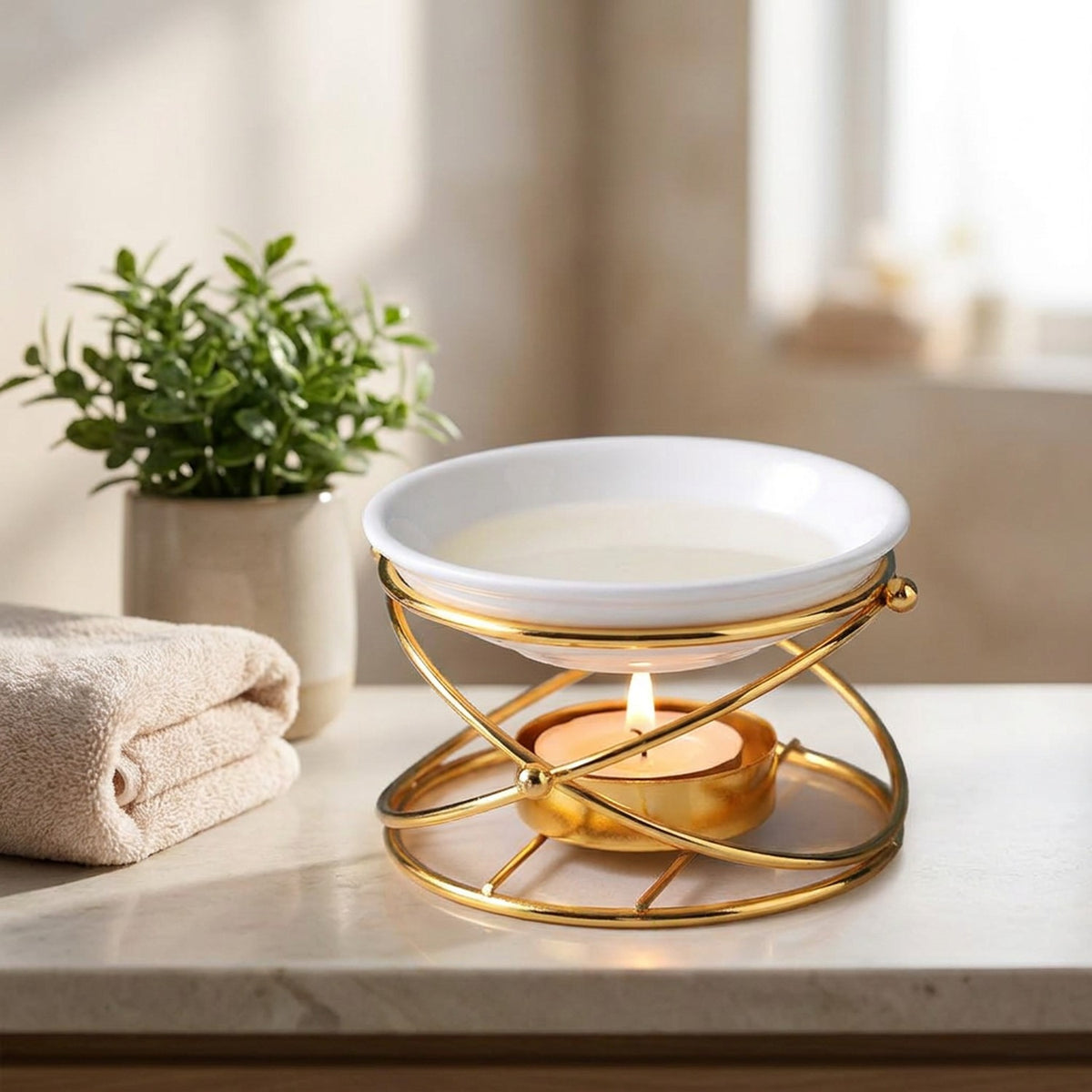 Brûleur d'huile essentielle doré posé dans une salle de bain spa avec serviette et plante verte