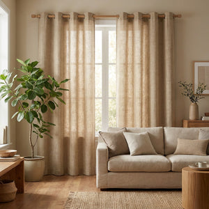 Rideau en lin beige à œillets dans un salon naturel avec canapé en lin et plante verte