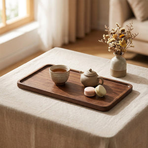 Plateau en bois de noyer avec théière tasse et macarons sur une table en lin
