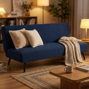 Housse de canapé convertible bleu marine avec coussins et plaid dans un salon cocooning