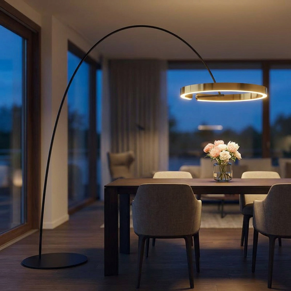 Lampadaire arc doré allumé au-dessus d'une table à manger dans une salle à manger moderne