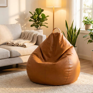 Pouf poire en simili cuir caramel dans un salon cosy avec canapé en lin et plantes