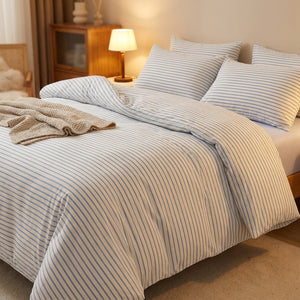 Parure de lit rayée bleue dans une chambre cocooning avec lampe de chevet