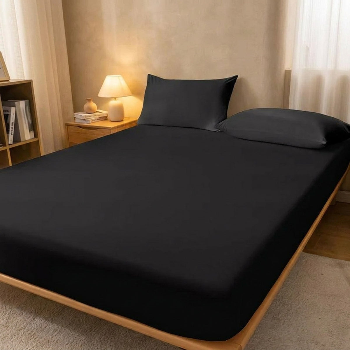 Drap housse noir sur un lit avec table de chevet en bois et lampe allumée