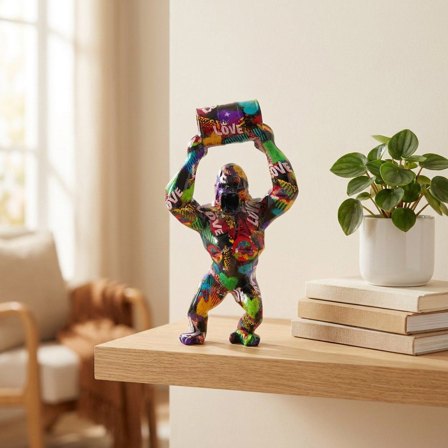 Statue gorille street art colorée sur une étagère en bois avec des livres et une plante