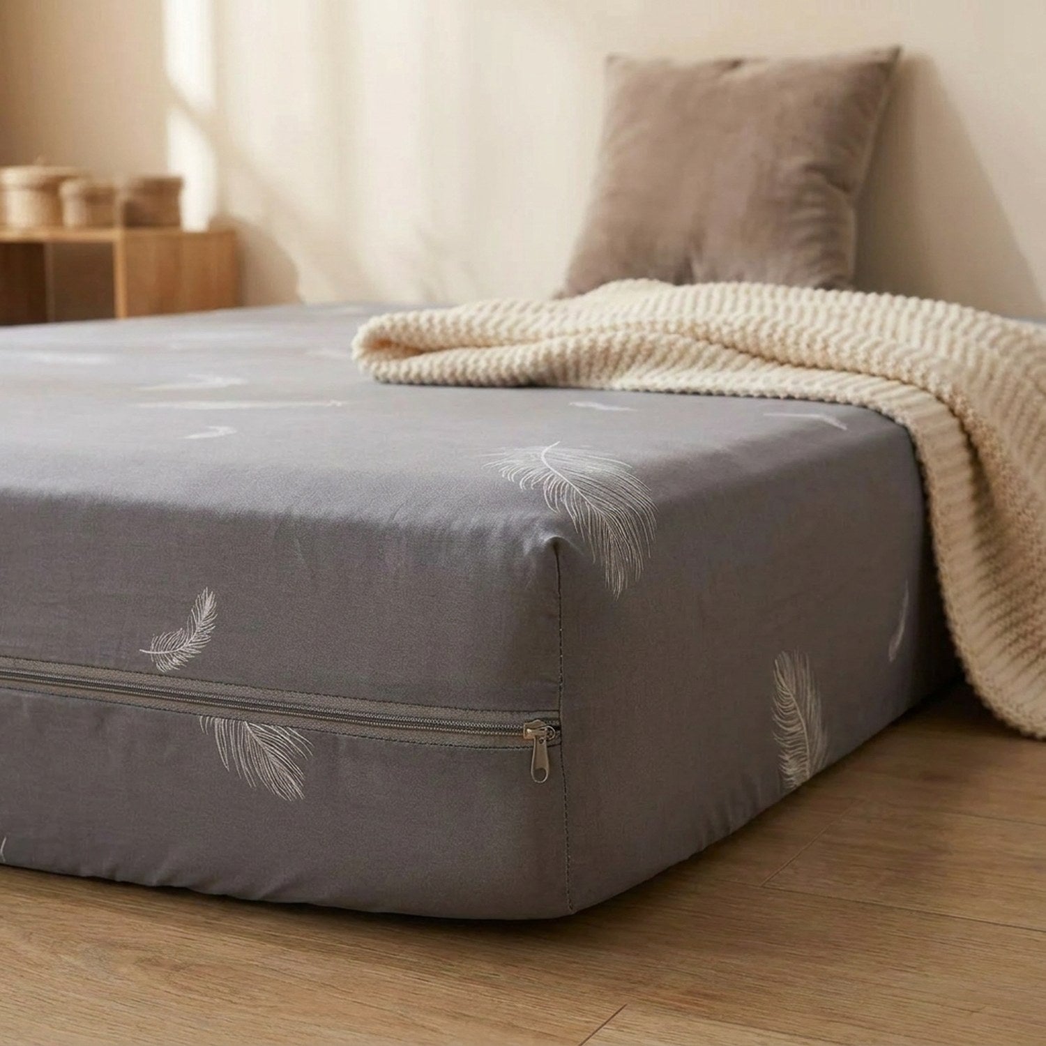 Détail de la housse de matelas grise à plumes avec sa fermeture éclair sur le côté