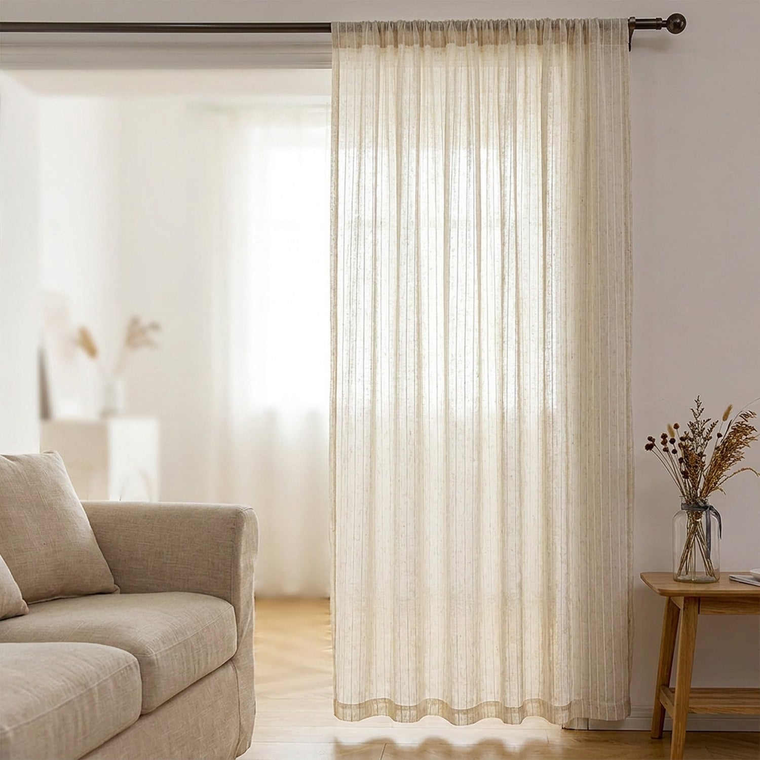 Voilage beige aspect lin suspendu dans un salon lumineux près d'un canapé