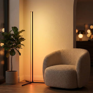 Lampadaire d angle LED RGB noir en lumière ambrée près d un fauteuil dans un salon