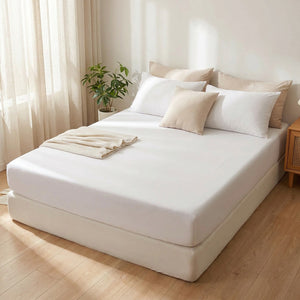 drap-housse blanc lisse et tendu sur un lit dans une chambre claire