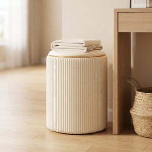 Tabouret de rangement beige avec un plaid plié dans une entrée près d'une console