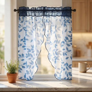 Voilage feuilles bleu installé dans une fenêtre de cuisine avec plante aromatique