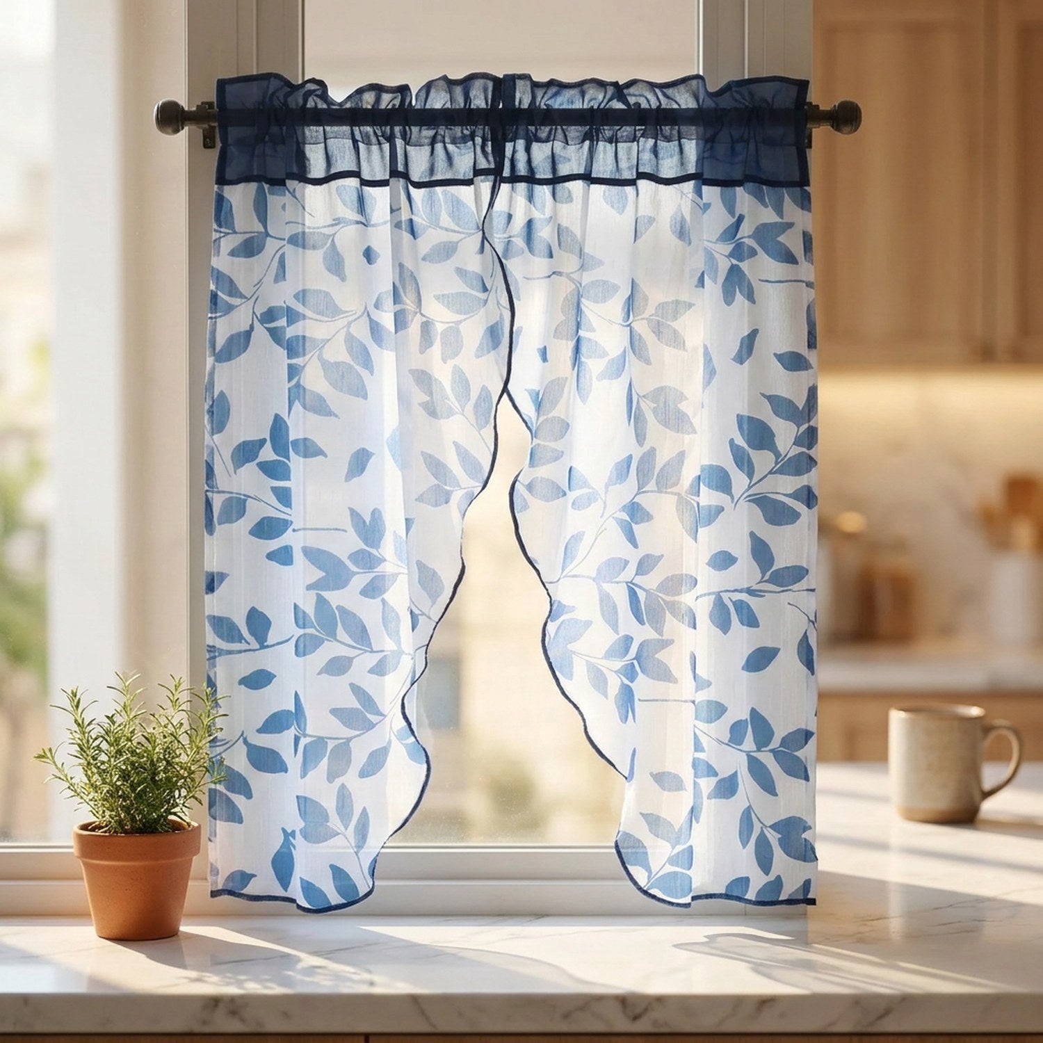 Voilage feuilles bleu installé dans une fenêtre de cuisine avec plante aromatique