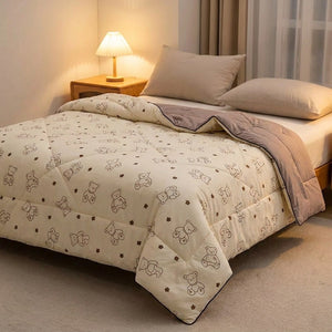 Couette légère à motif petits ours sur un lit dans une chambre chaleureuse avec lampe de chevet