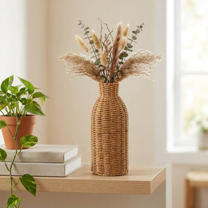 Vase en rotin tressé sur une étagère en bois avec eucalyptus séché et plante