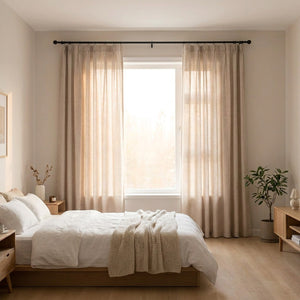 Rideau beige à œillets suspendu dans une chambre lumineuse avec lit blanc et plaid en maille