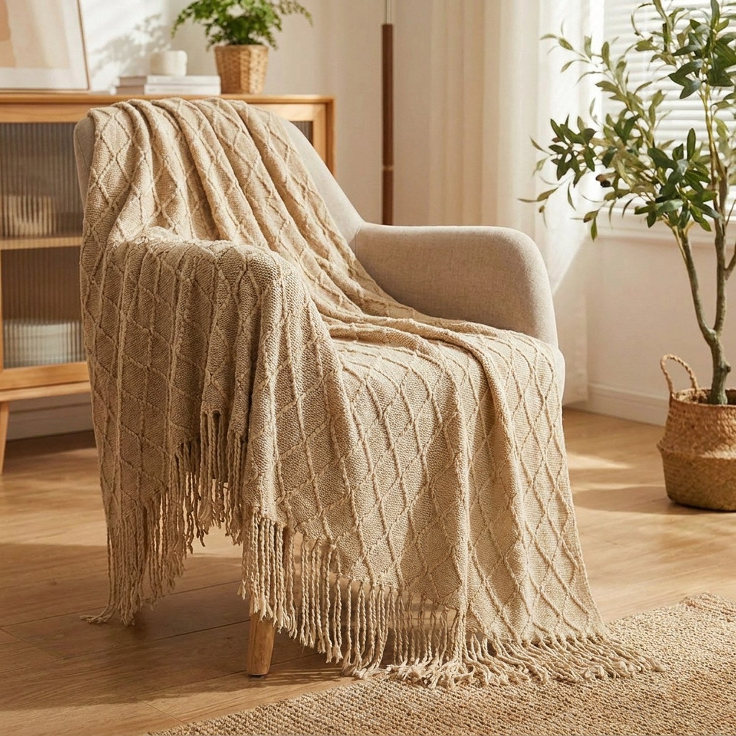 Couverture tricotée kaki à franges drapée sur un fauteuil dans un salon bohème