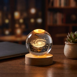 Lampe boule de cristal galaxie allumée sur un bureau la nuit