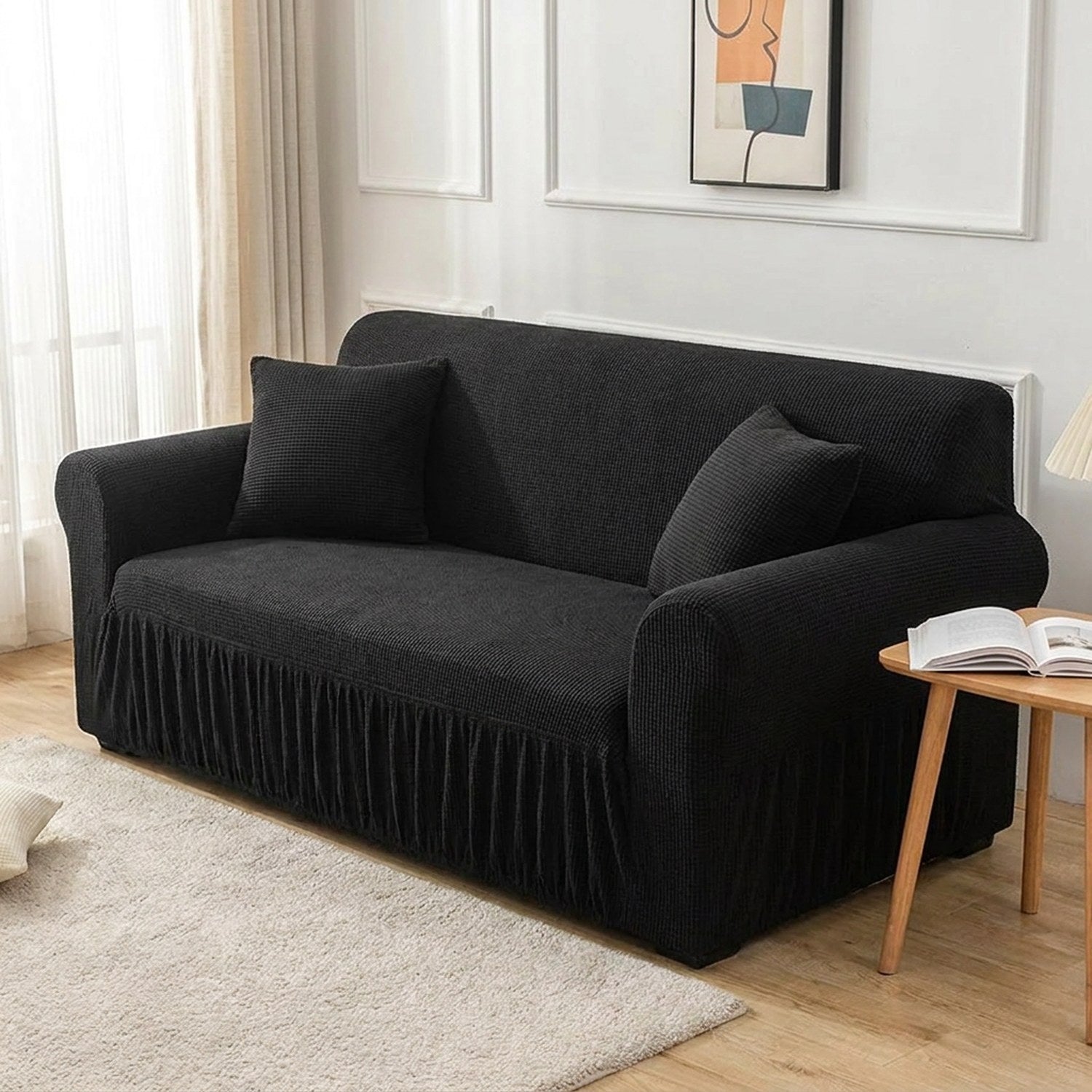 Housse de canapé noire dans un salon scandinave lumineux avec coussins assortis