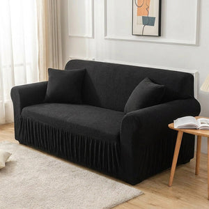 Housse de canapé noire dans un salon scandinave lumineux avec coussins assortis