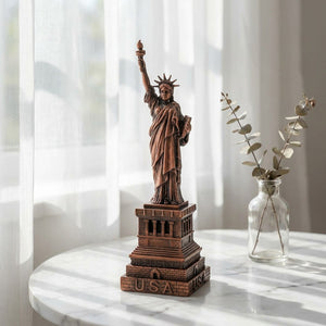 Statuette de la Liberté en métal bronze sur surface en marbre avec rideau voilage et branche d'eucalyptus