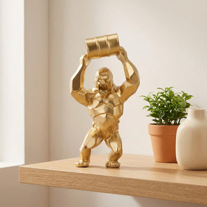 Statue gorille dorée sur une étagère en bois avec une plante