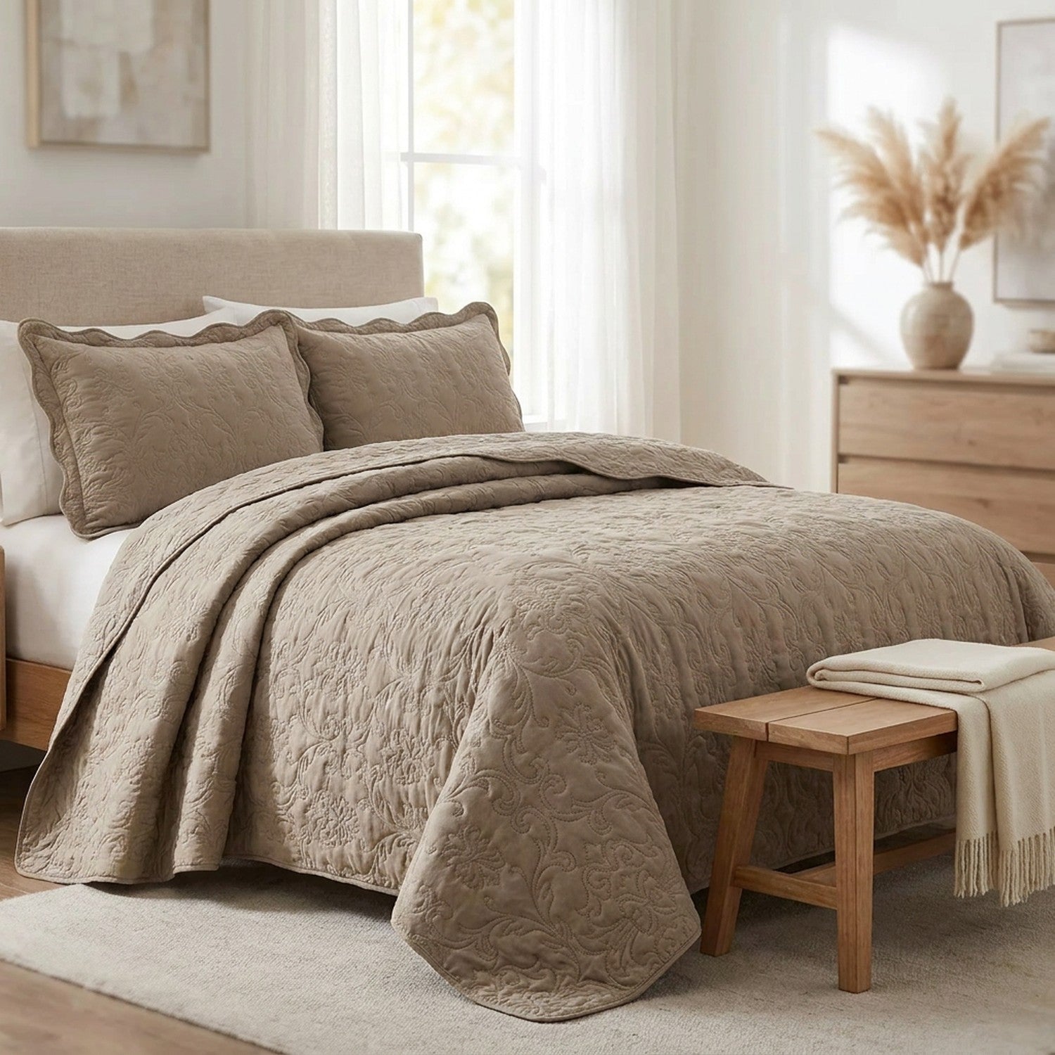 Couvre-lit matelasse taupe deploye sur un lit dans une chambre lumineuse et elegante