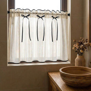 Rideau café transparent installé sur la fenêtre d'une salle de bain avec vasque en bois