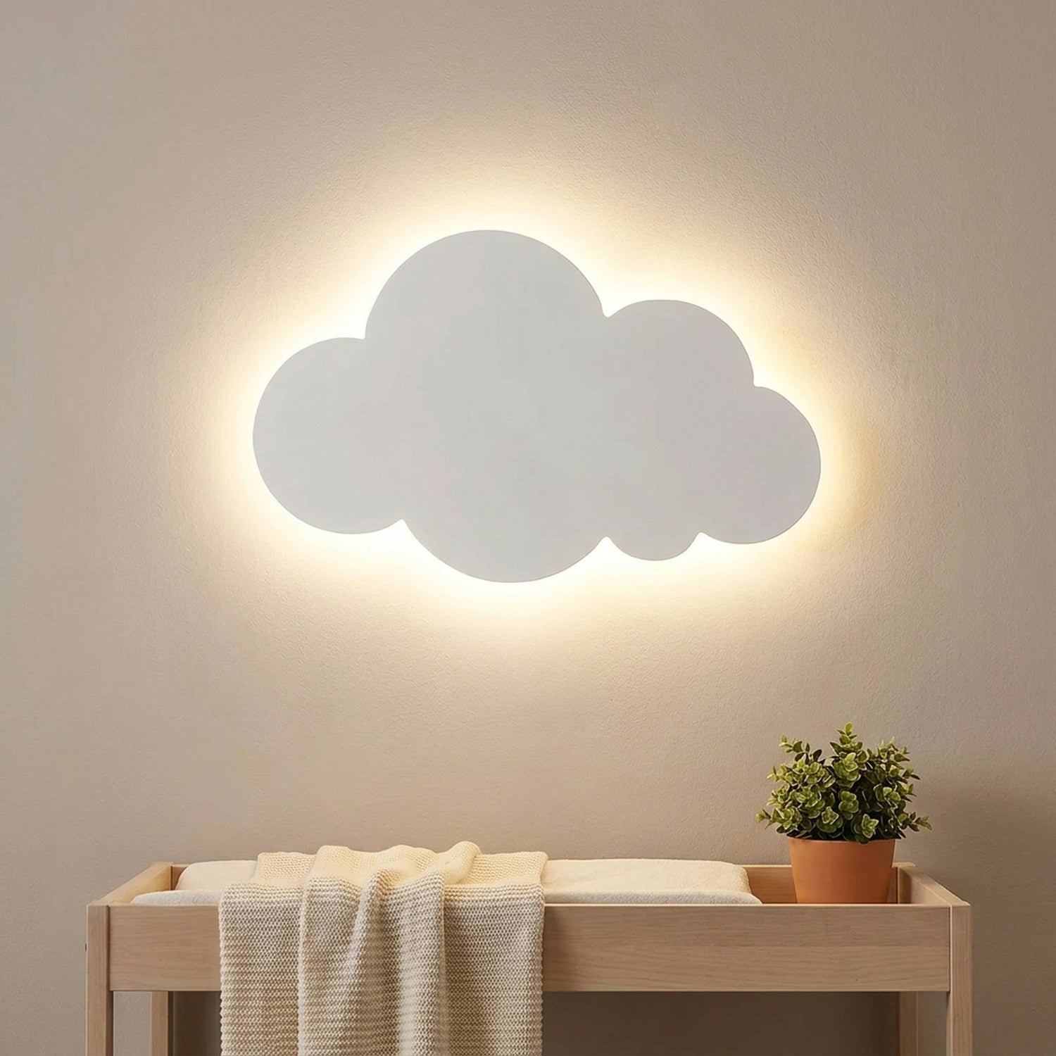 Applique nuage blanche allumée au dessus d'une table à langer dans une chambre de bébé
