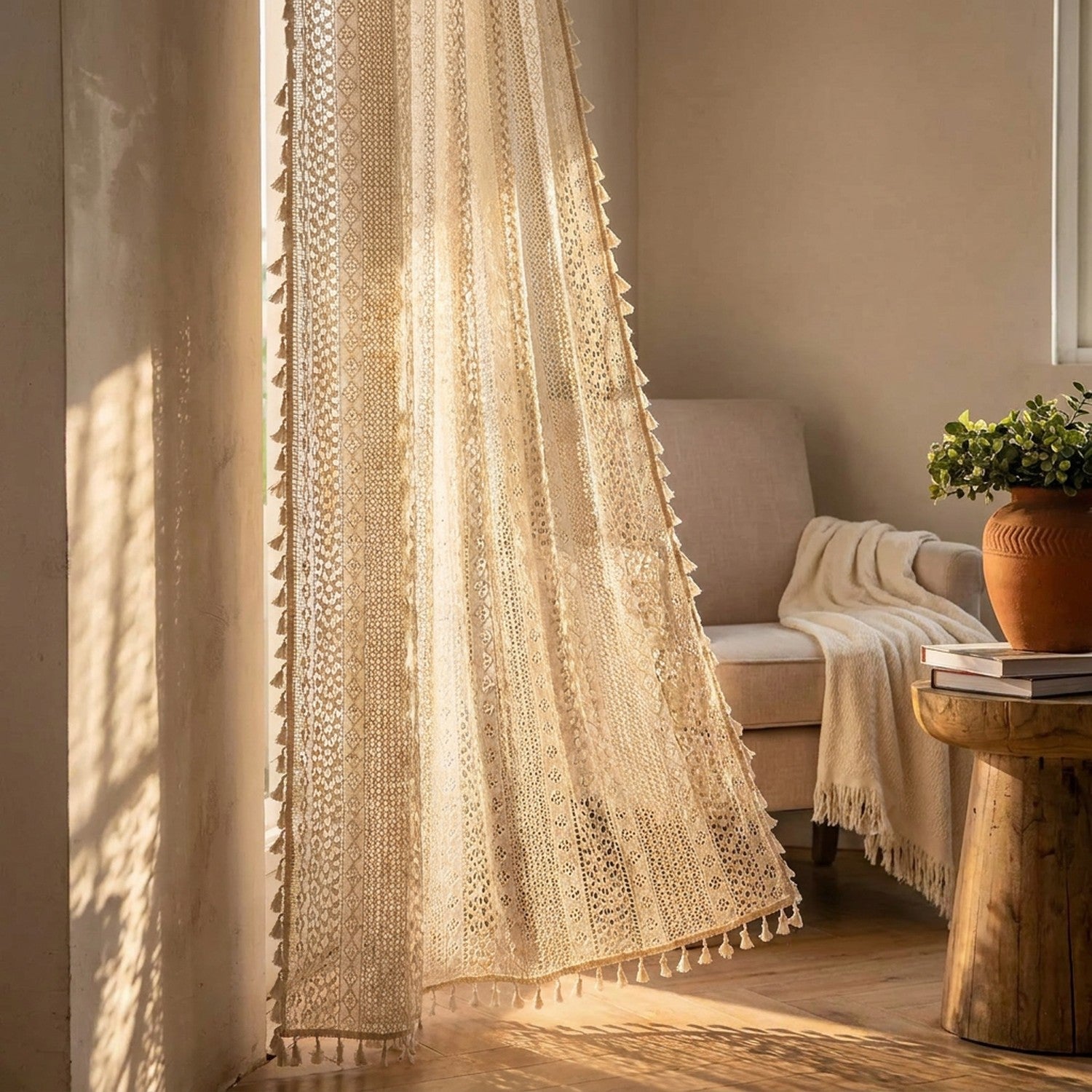 Lumière du jour filtrée par un rideau en dentelle au crochet beige à pompons