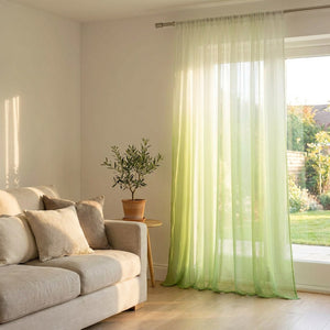 Voilage tulle dégradé vert dans un salon lumineux avec canapé et plante