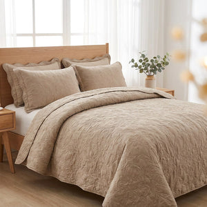 Couvre-lit matelassé beige sur un lit dans une chambre lumineuse et épurée