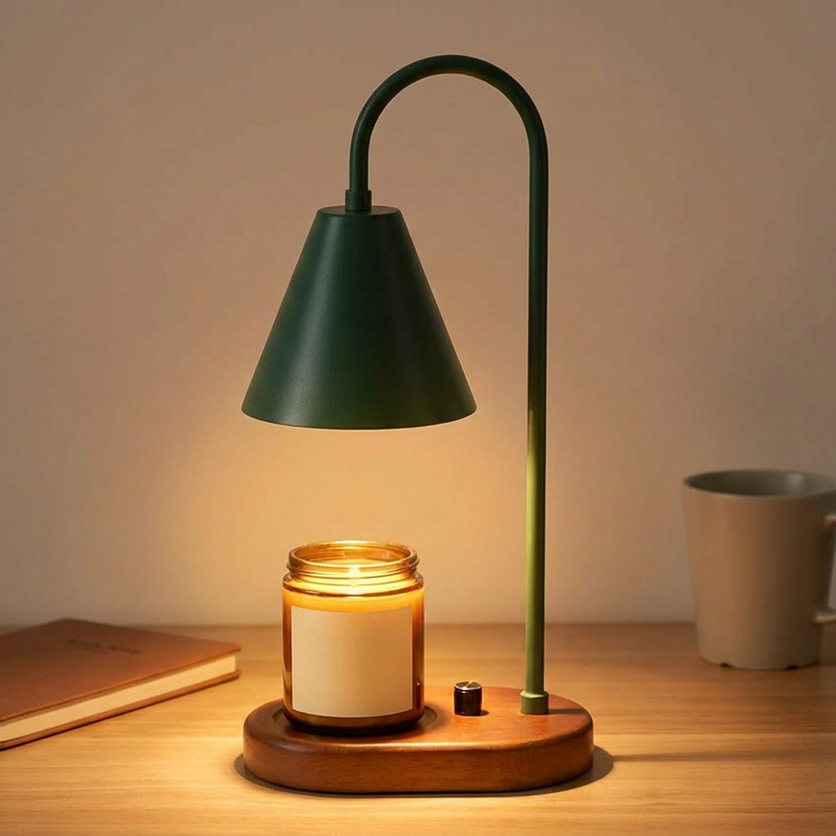 Lampe chauffe-bougie verte avec socle en bois sur un bureau avec un carnet et une tasse