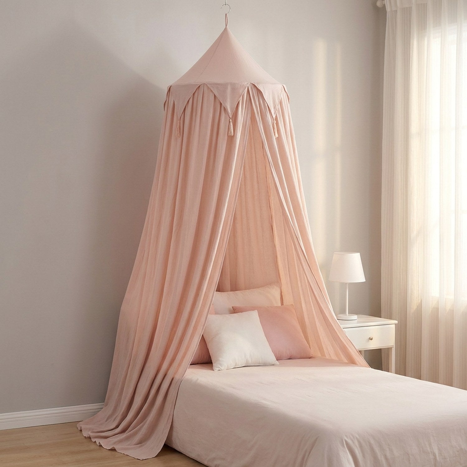 Moustiquaire à dôme rose poudré suspendue au-dessus d'un lit dans une chambre de fille épurée