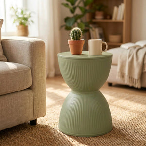Tabouret rond nordique vert sauge utilisé comme table d'appoint dans un salon