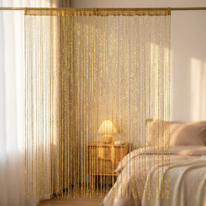 Rideau à fils doré devant une fenêtre dans une chambre lumineuse