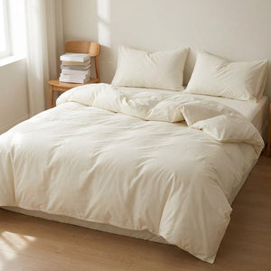 Parure de lit blanche dans une chambre lumineuse avec chaise en bois