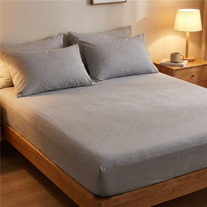 Drap housse gris dans une chambre moderne avec lampe de chevet allumee le soir