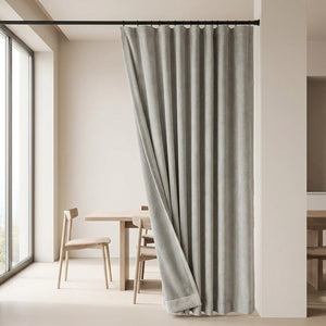 Rideau occultant gris velours chenille suspendu près d'une table à manger moderne