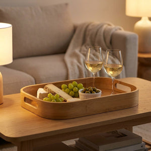 Plateau en bambou présentant un apéritif fromage et vin sur une table basse de salon