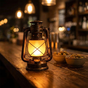 Lanterne vintage allumée posée sur un comptoir de bar en bois avec bols d'olives