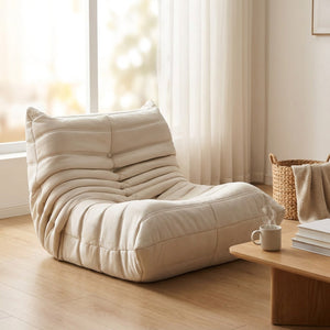 Pouf géant canapé de sol beige dans un salon scandinave lumineux près d une grande fenêtre