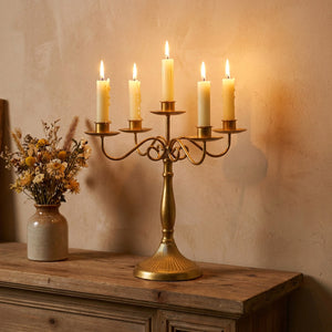Chandelier doré vintage allumé sur une cheminée en bois