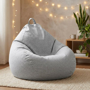 Pouf poire gris dans un coin cocooning avec guirlande lumineuse et plantes