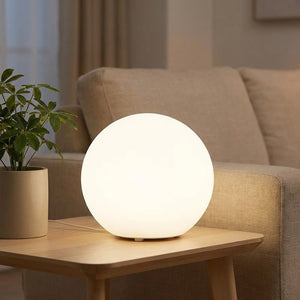 Lampe boule en lumière blanche sur une table basse près d un canapé