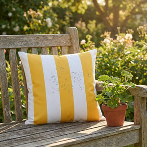 Housse de coussin imperméable rayée jaune sur un banc de jardin avec gouttes d'eau