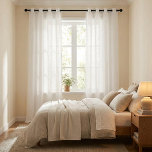Rideaux en lin blanc dans une chambre cocooning avec lit en lin