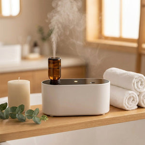 Diffuseur d'huile essentielle blanc sur une étagère de salle de bain avec des serviettes roulées