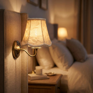 Abat-jour en velours sur une applique de chevet allumée dans une chambre cosy