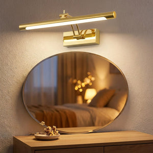 Applique murale miroir LED dorée au-dessus d'un miroir ovale sur une coiffeuse en bois