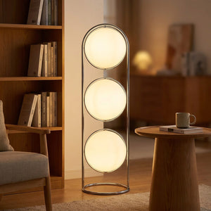 Lampadaire trois boules opalines dans un coin lecture avec bibliothèque